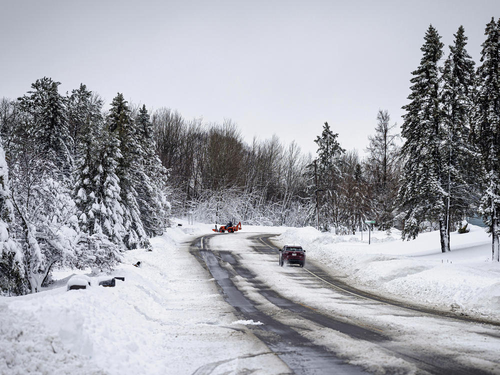 A car slowly travels down a road after a second round of snow passed through northern Minnesota Thursday, Dec. 15, 2022, in Duluth, Minn.