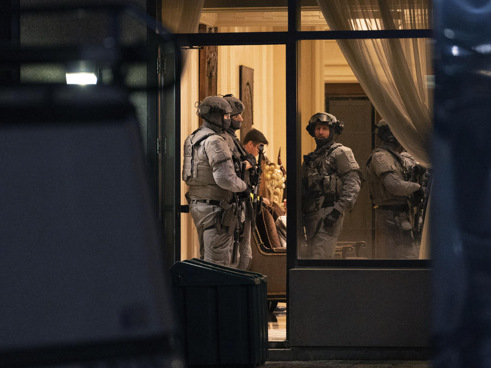 York Regional Police tactical officers stand in the lobby of a condominium building in Vaughan, Ontario, Sunday, Dec. 18, 2022. Police said multiple people are dead, including the suspect, after a shooting in a unit of the building.
