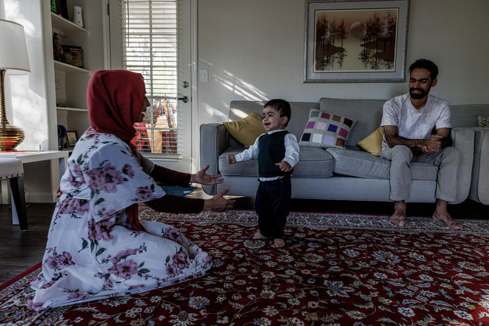 Afghan helicopter pilot Rashid Ahmad Muslim, 25, with his wife, Nasrin Halimi, 22, who is three months pregnant, and their son Mohammad, 14 months, in their home in Chandler, Ariz., on Dec. 11, 2022.