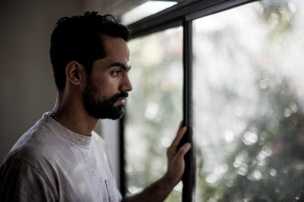 Afghan helicopter pilot Rashid Ahmad Muslim, 25, looks out the window at home in Chandler, Ariz., on Dec. 11, 2022.