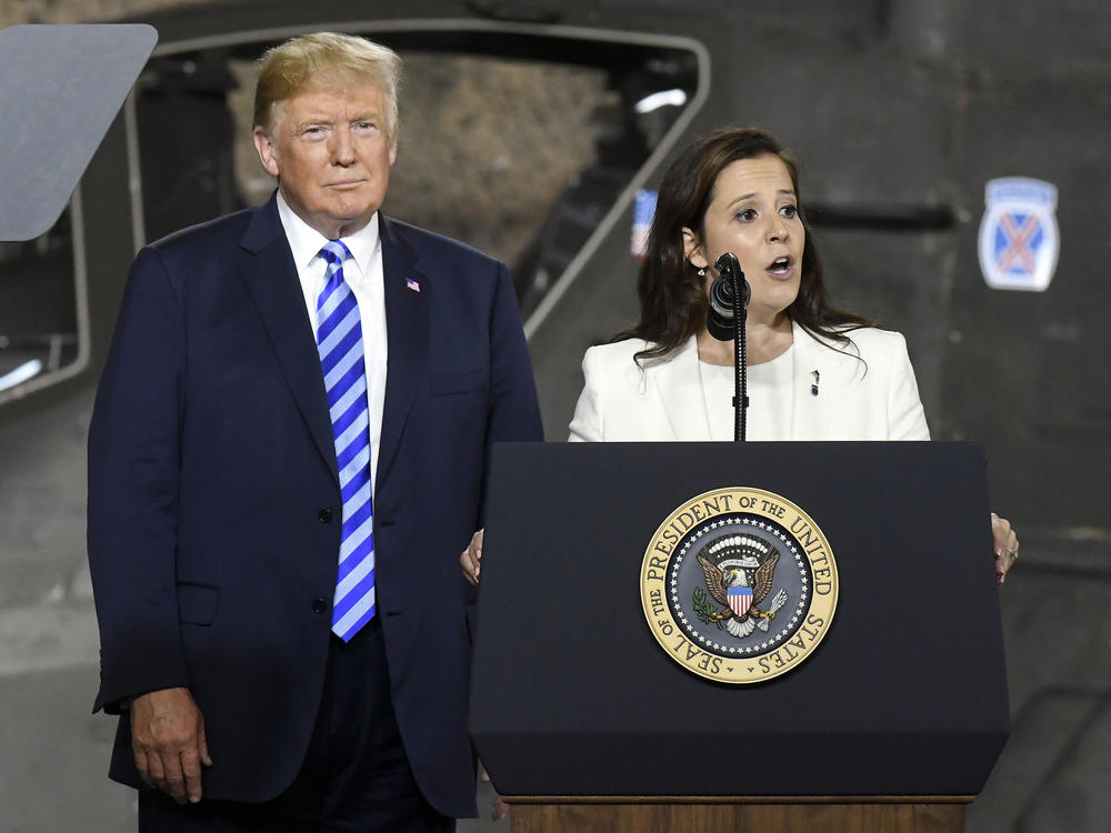 FILE - Former President Donald Trump, left, listens as Rep. Elise Stefanik, R-N.Y., speaks at Fort Drum, N.Y.