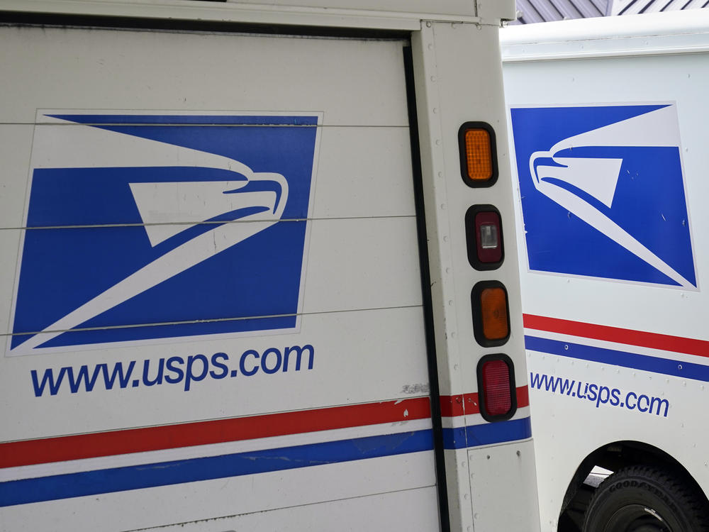 Mail delivery vehicles are parked outside a post office in Boys Town, Neb., on Aug. 18, 2020. The Postal Service said Tuesday it will sharply increase the number of electric-powered delivery trucks in its fleet and will go all-electric for new purchases starting in 2026.