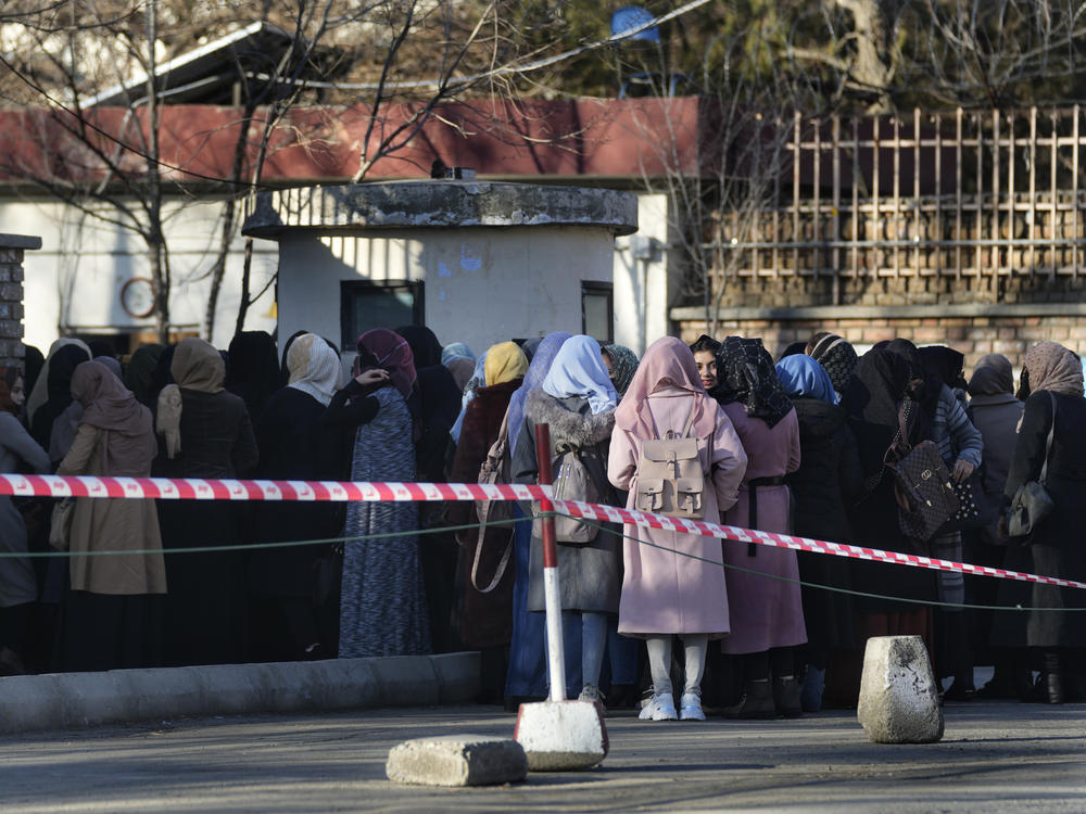 Afghan students queue at one of Kabul University's gates in Kabul, Afghanistan, on Feb. 26. Women are banned from private and public universities in Afghanistan until further notice, a Taliban government spokesman said Tuesday.