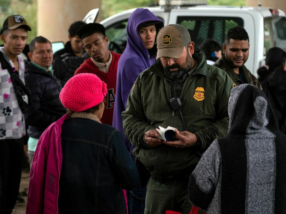 A Border Patrol agent checks an asylum-seeker's passport after she turned herself in, in Eagle Pass, Texas, on Dec. 19.