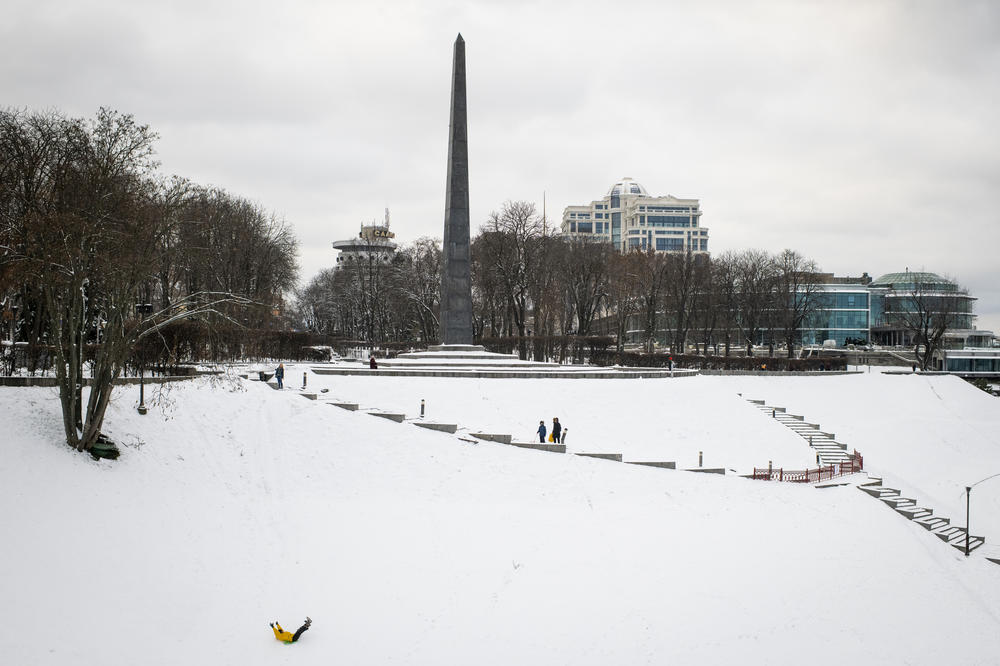 People sled on a hill in the Park of Eternal Glory adjacent to the Tomb of the Unknown Soldier in Kyiv on Nov. 30.