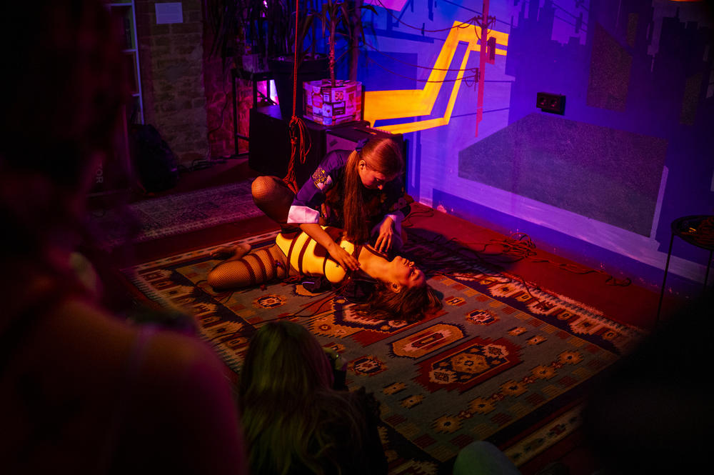 A bar in a former squat in Kyiv frequently hosts events to raise money for the military. At one such event on Dec 1, Kateryna Havrylchuk, top, and Ksenia Zhmurko demonstrate shibari, a style of Japanese bondage.
