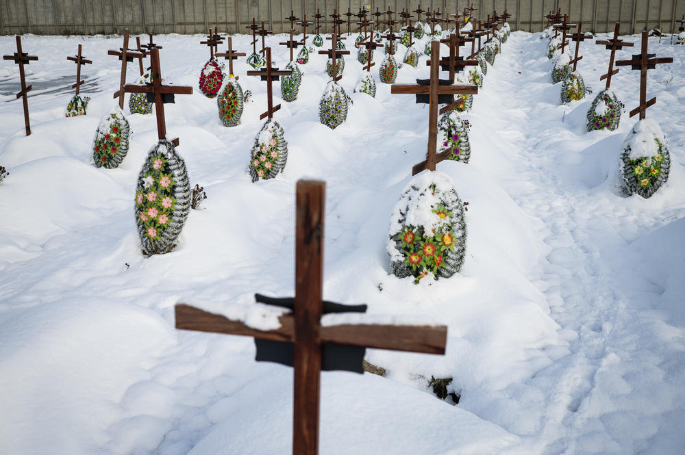 Fresh graves are covered by snow in Bucha on Dec. 2. Many feature numbers rather than names because the bodies are unidentified.