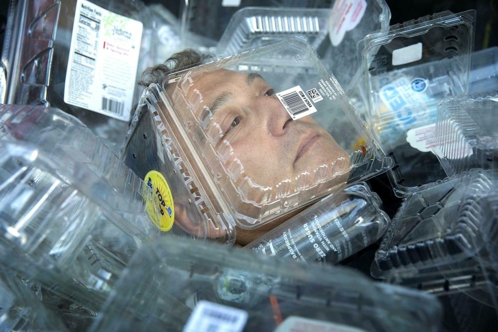 JD Cohen prepares to be completely covered in plastic packaging at a performance of 