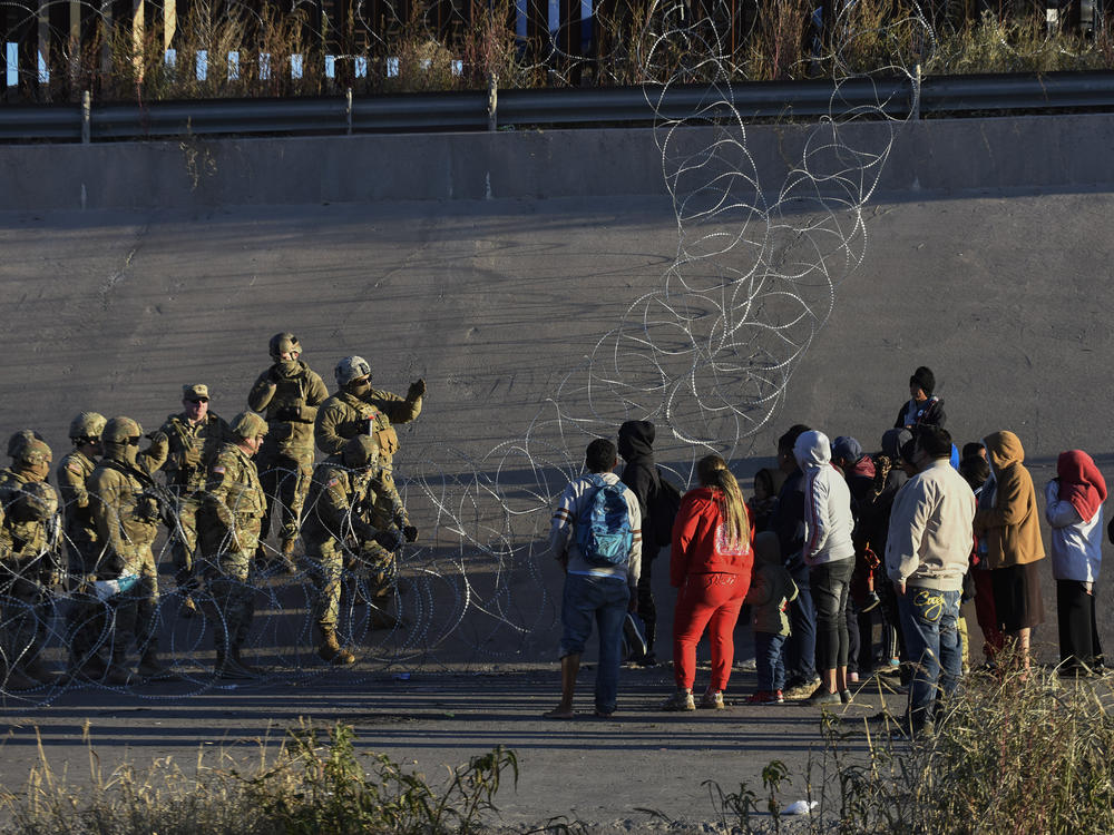 U.S. military stop migrants from crossing into El Paso, Texas, seen from Ciudad Juarez, Mexico, Tuesday, Dec. 20, 2022. The U.S. Supreme Court issued a temporary order to keep pandemic-era limits on asylum-seekers in place, though it could be brief, as conservative-leaning states push to maintain a measure that allows officials to expel many but not all asylum-seekers.