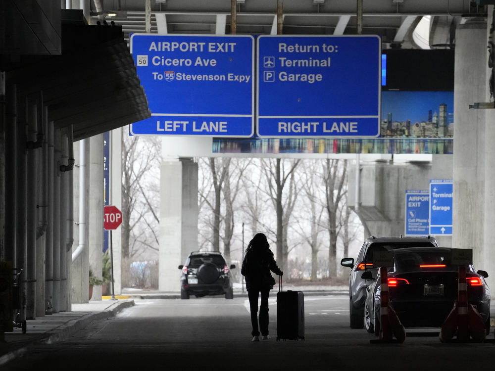 An airline passenger walks to her ride share vehicle after arriving at Chicago's Midway Airport just days before a major winter storm Tuesday, Dec. 20, 2022, in Chicago.