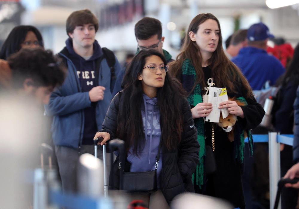 Travelers arrive for flights at the O'Hare International Airport, in Chicago, on December 16.