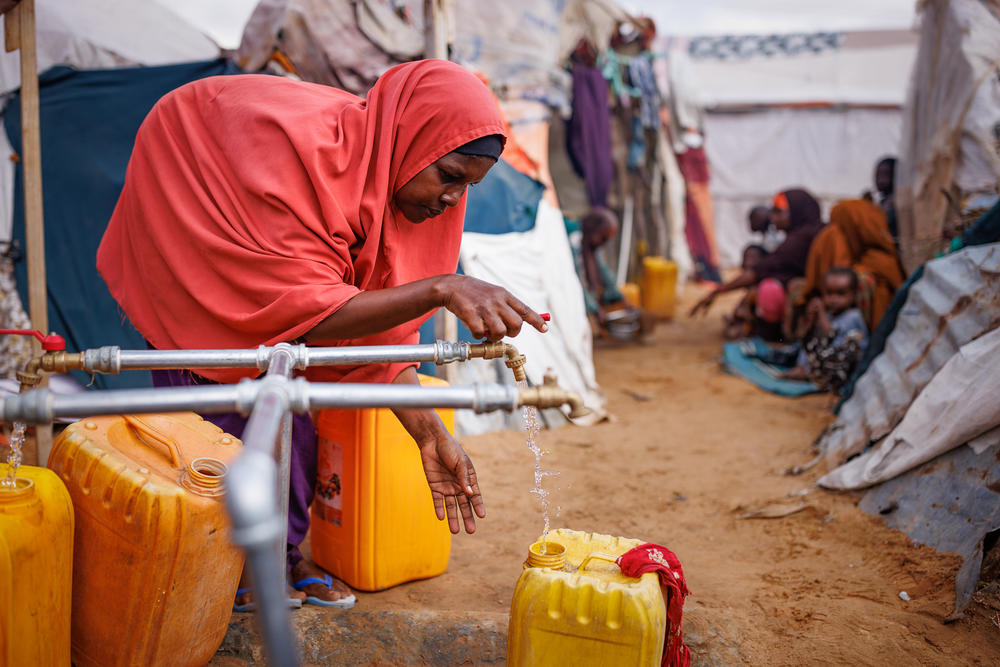 A woman fills jerry cans with water in a camp for displaced persons on the outskirts of Mogadishu, Somalia, on Dec. 17.