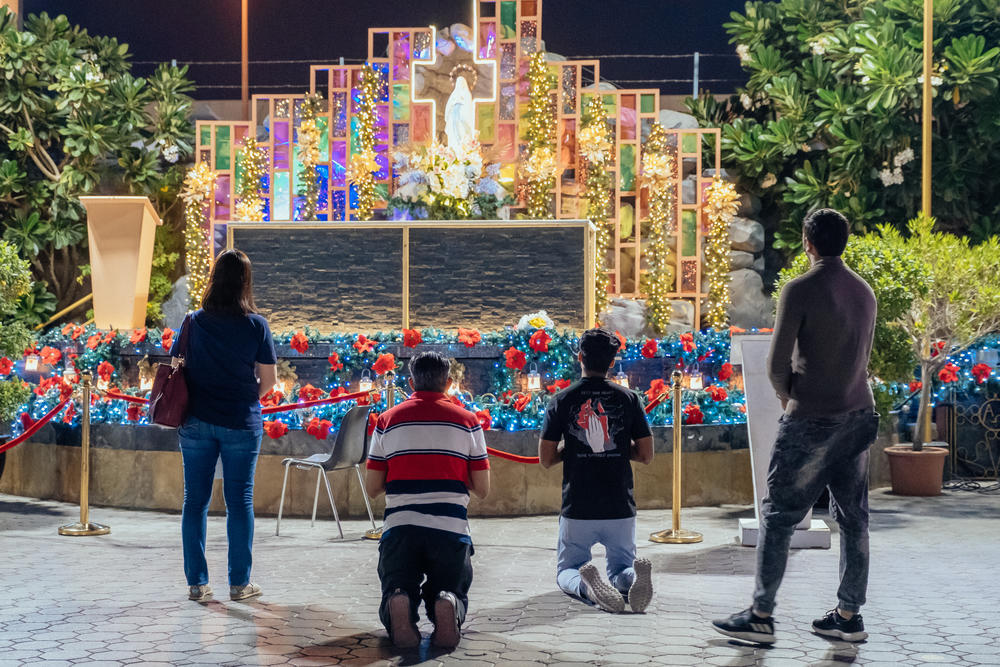 People pray in the St. Mary's Catholic Church courtyard. Churches and other non-Muslim places of worship must obtain operating licenses from the UAE government.