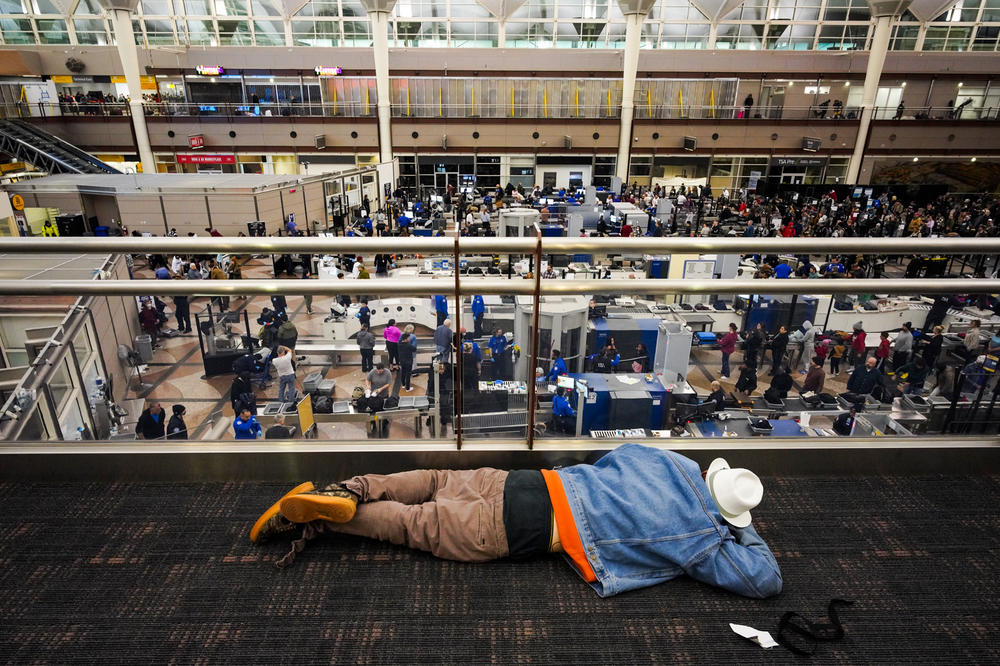 A traveler sleeps on the floor at Denver International Airport on Thursday morning, where temperatures dipped to minus 24 degrees.