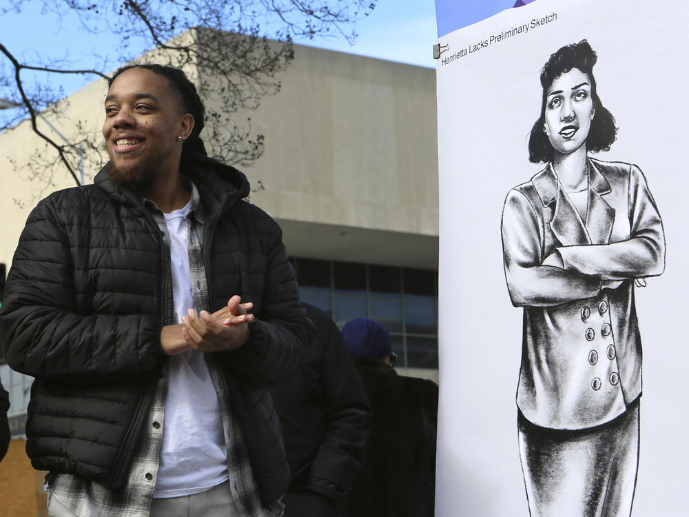 Artist Bryce Cobbs stands next to the drawing he created of Henrietta Lacks, which was unveiled in Roanoke, Va., on Monday. The drawing will be used in the design process of a larger-than-life bronze statue.