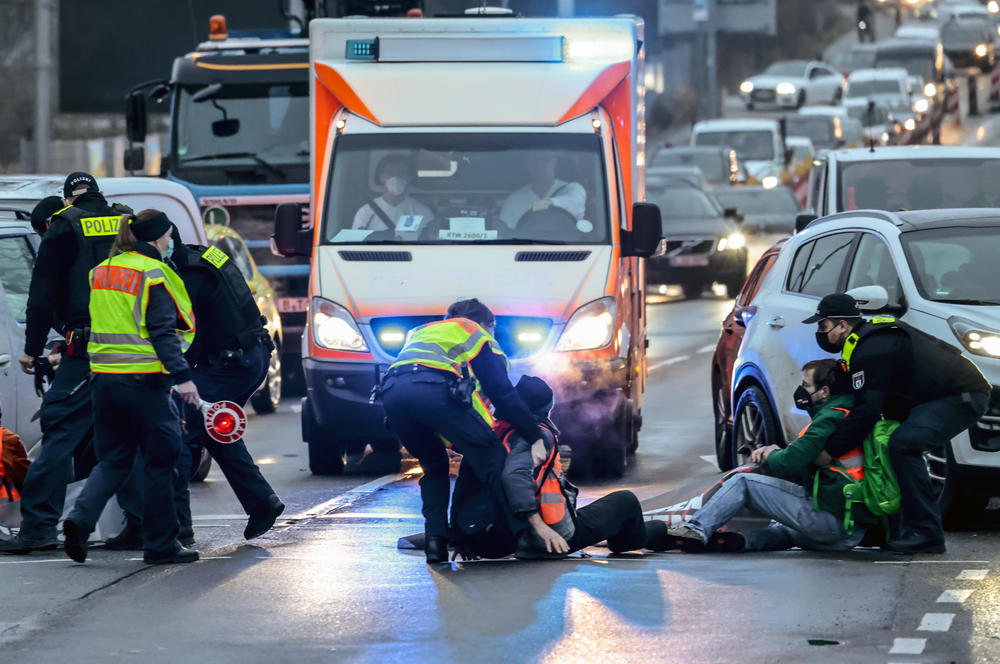 Police officers move Letzte Generation activists blocking the end of a highway during a protest against food waste on Jan. 24, near Berlin.