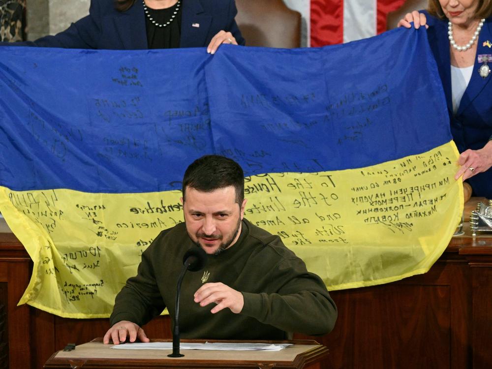 House Speaker Nancy Pelosi and Vice President Harris hold up a Ukrainian flag while Ukrainian President Volodymyr Zelenskyy speaks to Congress on Wednesday evening.