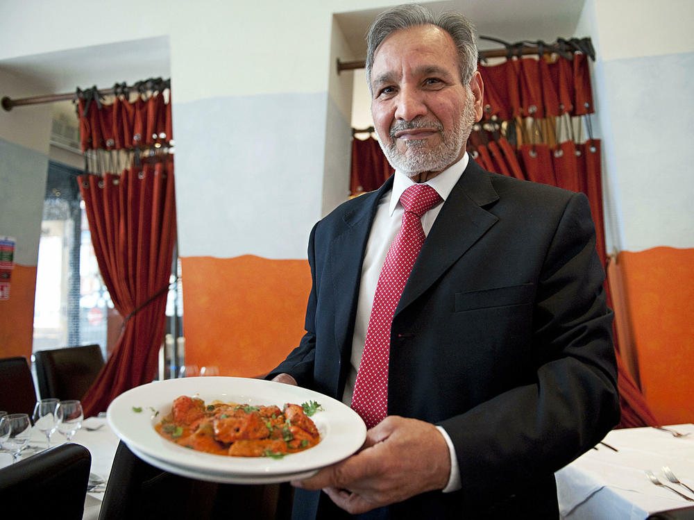 Ahmed Aslam Ali, the owner of the Shish Mahal restaurant in Glasgow, Scotland, is pictured with a plate of chicken tikka masala in his restaurant, on July 29, 2009.