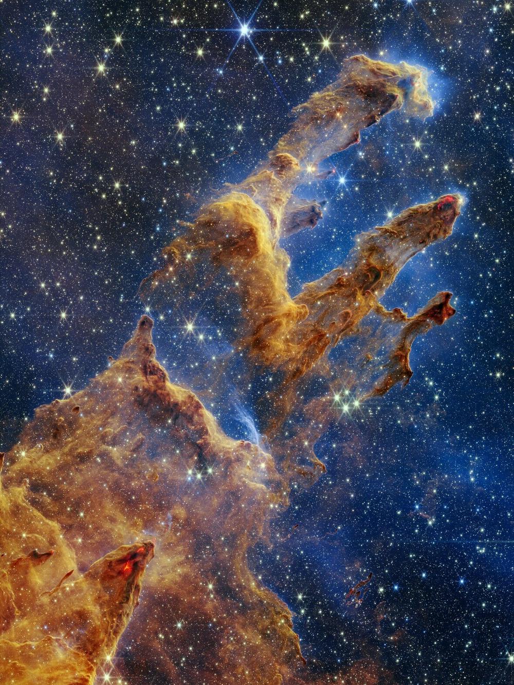 The Pillars of Creation were first photographed by Hubble in 1995. Webb's image reveals countless newly formed stars glistening amongst the columns of gas and dust.