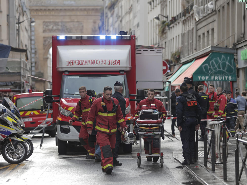 Fire brigade medics work on the scene where a shooting took place in Paris on Friday.