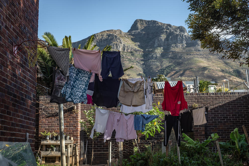 Laundry hangs on a line against a backdrop of Table Mountain in the back garden of Cissie Gool House.