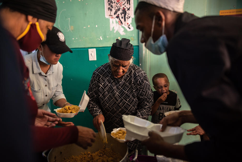 Auntie Sienna, a long-term resident of Cissie Gool House, distributes food donated to the occupants as a gift for Ramadan.