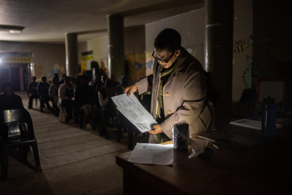 Community leader Shiela Madikane uses a battery-powered light to read through the agenda during a meeting at Ahmed Kathrada House, an abandoned nursing home in central Cape Town that has been occupied by a community of several hundred evictees and housing activists for nearly six years. The building's electricity was cut off by the city soon after the occupation.