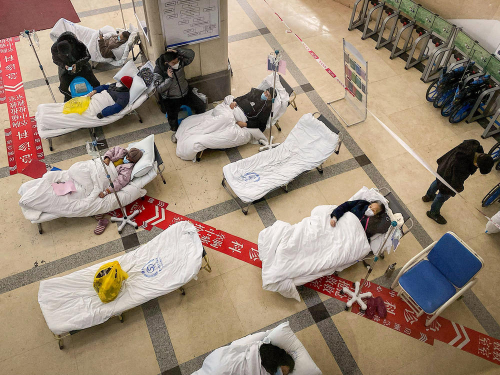 In some hospitals, like this one in Chongqing, one of China's largest cities, patients are lying on gurneys in the lobby because beds have run out.