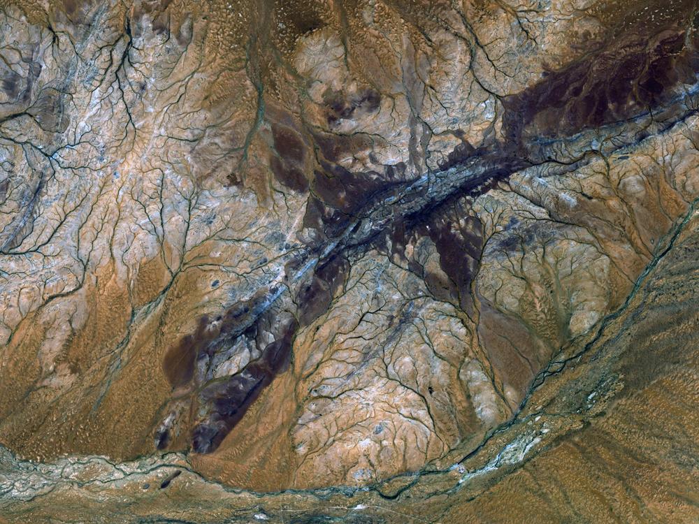 The oldest material on Earth which has yet been dated by humanity is a zircon mineral of nearly 4.4 billion years old from a sedimentary rock formation in the Jack Hills of western Australia, seen in this satellite image.