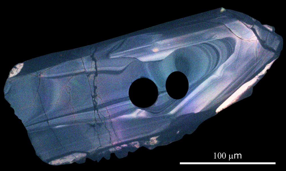 A zircon crystal estimated to be around 3.6 billion years old taken from the Jack Hills metaconglomerate of Western Australia. The concentric rings record processes that happened in the magma from which the zircon minerals crystallized billions of years ago. The black circles inside the crystal are the pits left by a laser beam that was used to determine the age and chemistry of the zircons.