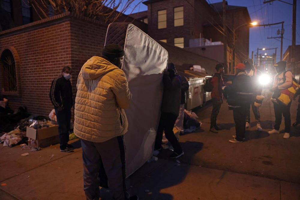 Unsheltered migrants move mattresses outsides Sacred Heart Church after crossing the Rio Grande into the United States in El Paso, Texas, on Thursday.