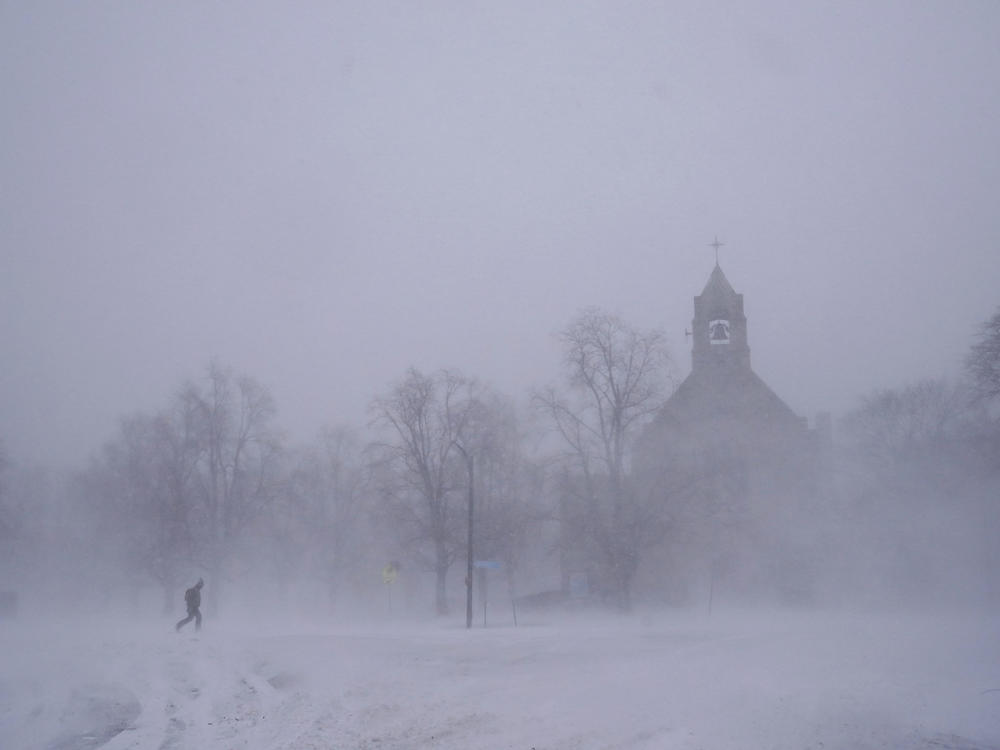 A lone pedestrian in snow shoes makes his way across Colonial Circle as St. John's Grace Episcopal Church rises above the blowing snow amid blizzard conditions in Buffalo, N.Y. on Saturday.