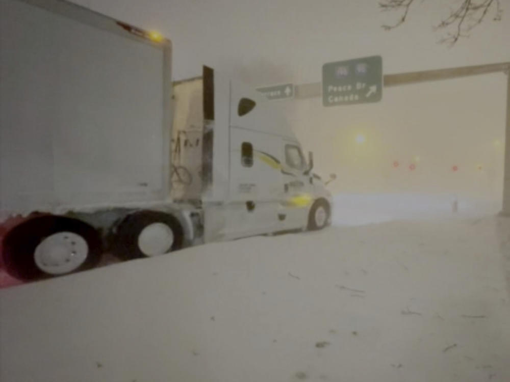 High winds and snow covers the streets and vehicles in Buffalo, N.Y., early Sunday.