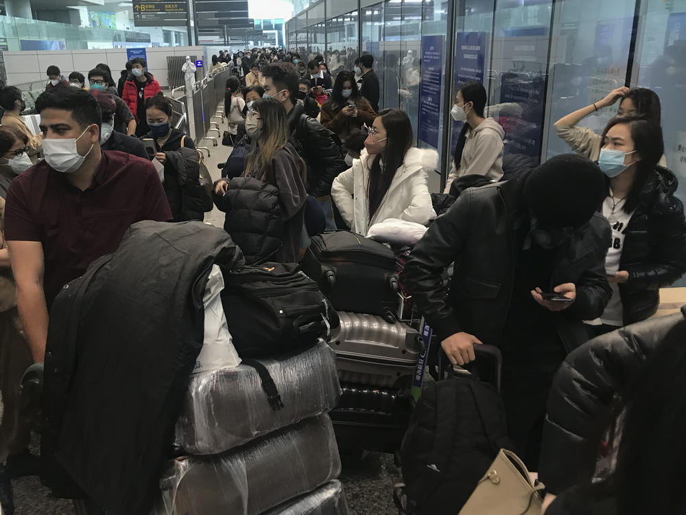 Inbound travelers wait for hours to board buses to leave for quarantine hotels and facilities from Guangzhou Baiyun Airport in southern China's Guangdong province on Dec. 25 2022.