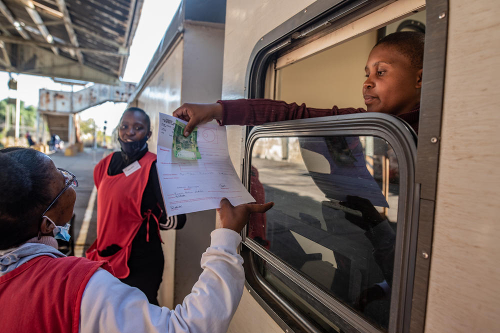A pharmacist on the Phelophepa health-care train takes payment for a patient's prescription.