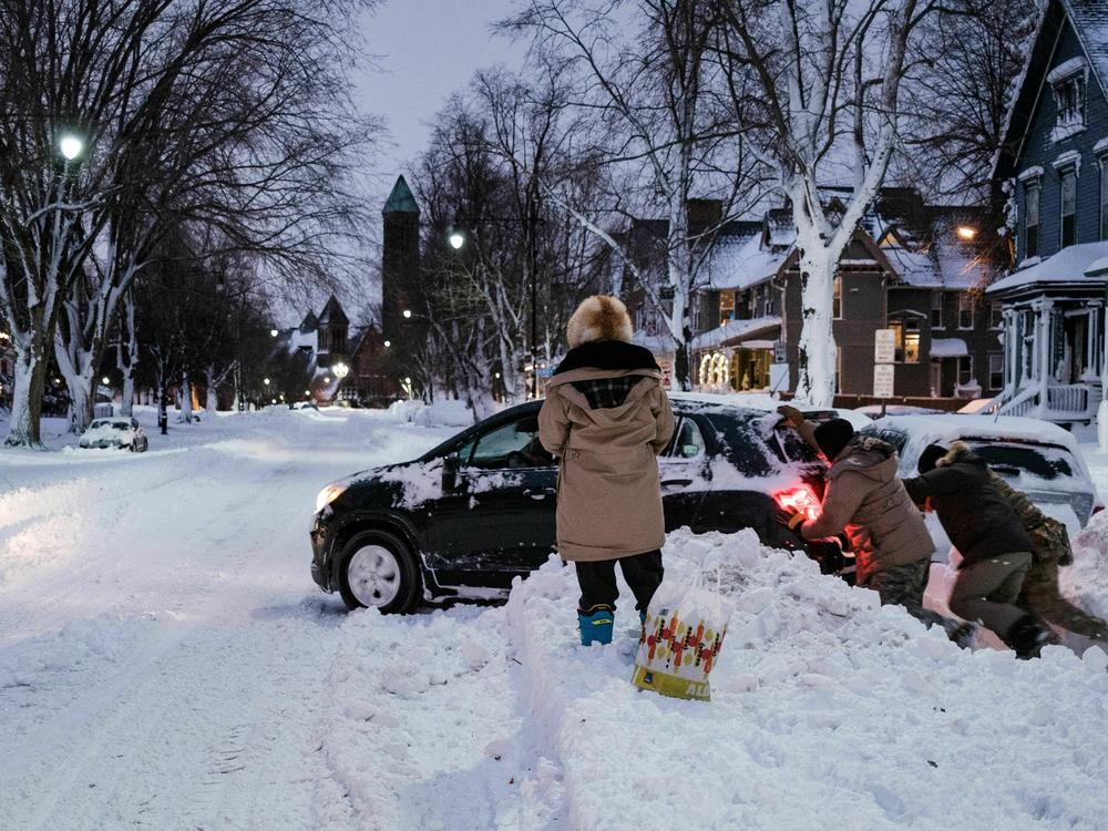 Members of the New York National Guard help free a car stuck in the snow in Buffalo, New York, on Christmas.