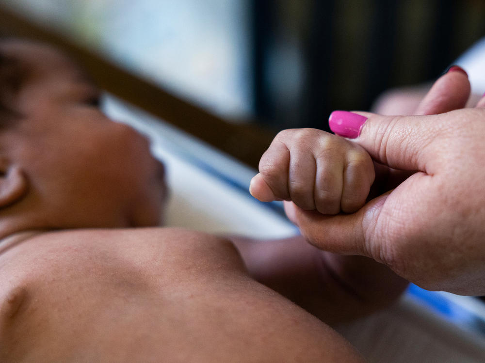 Registered nurse Carole Kriessman performs a quick checkup on Ja'Mil'Lion DeLorenzo's 4-week-old son, Haiyden, at DeLorenzo's grandmother's home in Glenolden, Pa., on June 9.