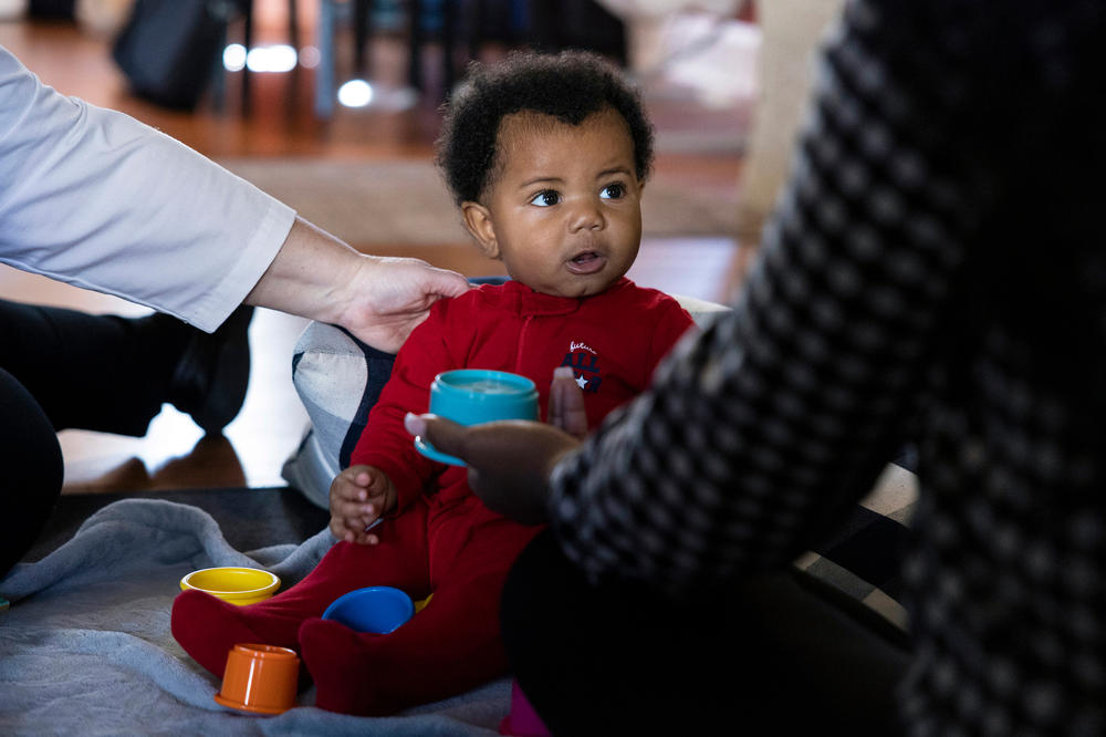 Haiyden Hackney sits up as his mother, Ja'Mil'Lion DeLorenzo, and nurse Carole Kriessman watch.