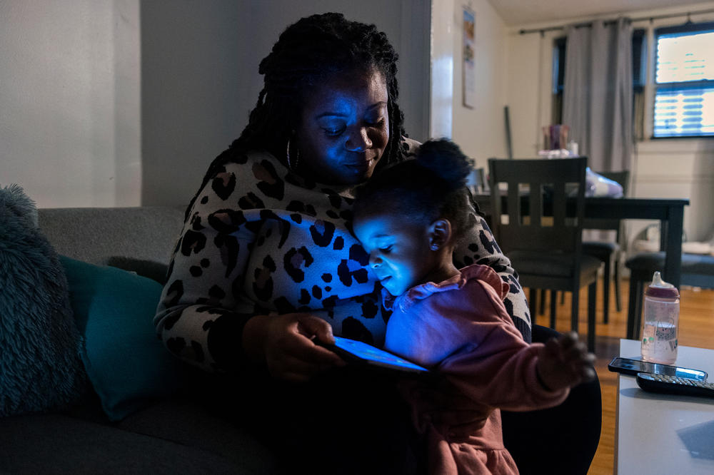 Lauren Brown and her daughter Bella Mumin watch a YouTube video.