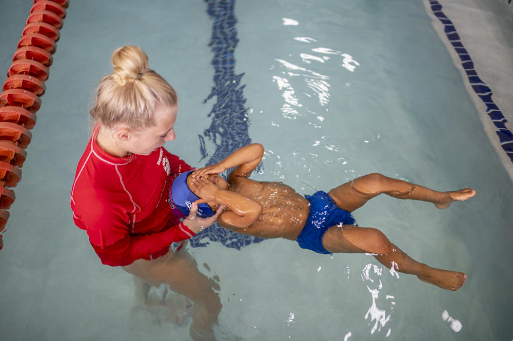 Ridhay Vemuri closes his eyes as his swim instructor holds him afloat during swimming lessons at a pool in South Lyon, Mich., on Oct. 16, 2022.