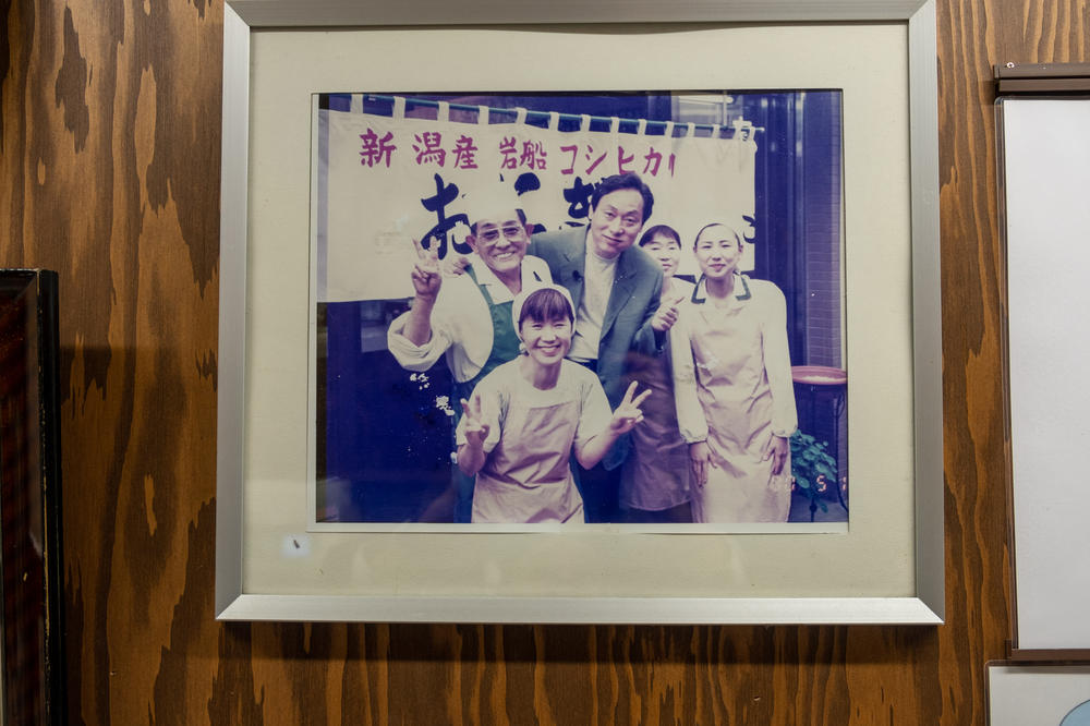 A picture on the wall at Onigiri Bongo shows the restaurant's original owner, Tasuku Ukon (back row, left), and his wife, the restaurant's current owner, Yumiko Ukon, in front of him.