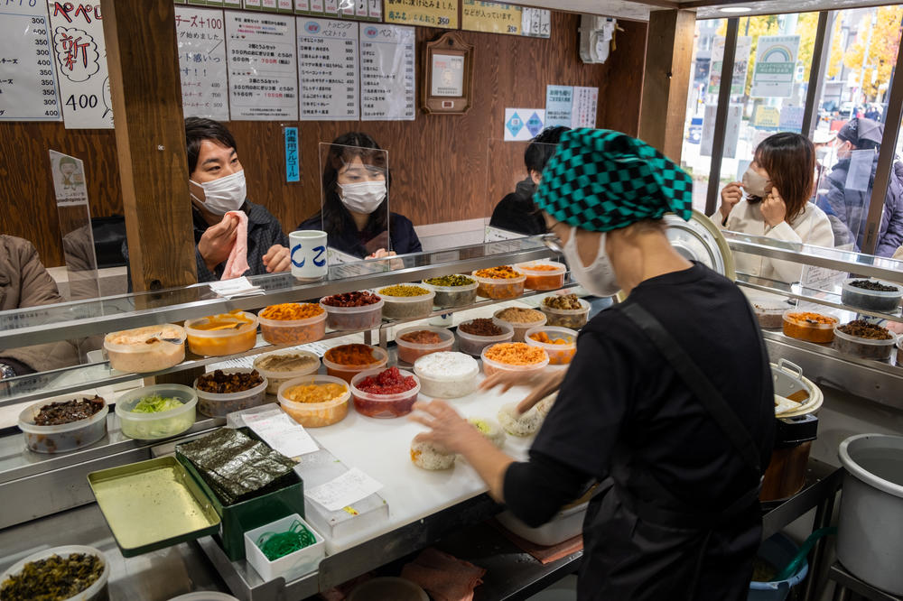 Onigiri Bongo owner Yumiko Ukon (foreground) prepares rice balls at her popular Tokyo restaurant. Ordering from a chef behind the counter is similar to the way many sushi restaurants operate.