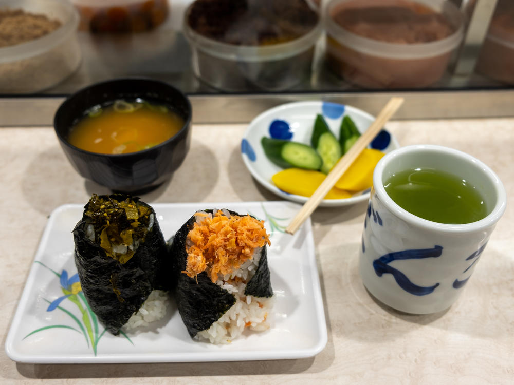A lunch at Onigiri Bongo includes mustard green and salmon flake onigiri, miso soup, pickles and green tea.