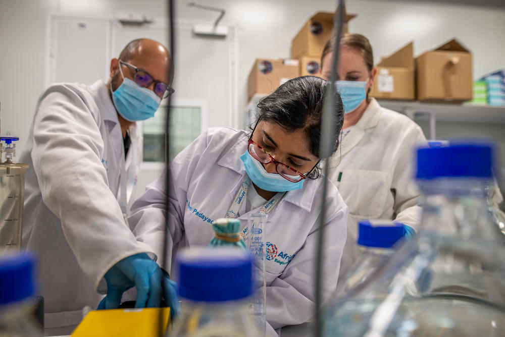 Scientists (left to right) Brandon Weber, Eden Padayachee and Tanja Smith work to fix the tubing of a peristaltic pump used to produce Afrigen's new mRNA vaccine against COVID. Now that the prototype has worked in mice, the team must develop a whole new system to make the much larger quantities needed for clinical trials in humans.