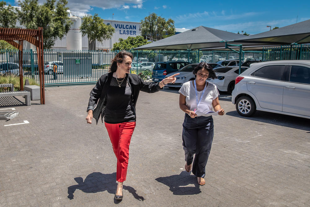 Afrigen's managing director Petro Terblanche and executive director Caryn Fenner rush to a meeting with the company's head of construction at the company's expanding premises in Cape Town, South Africa.