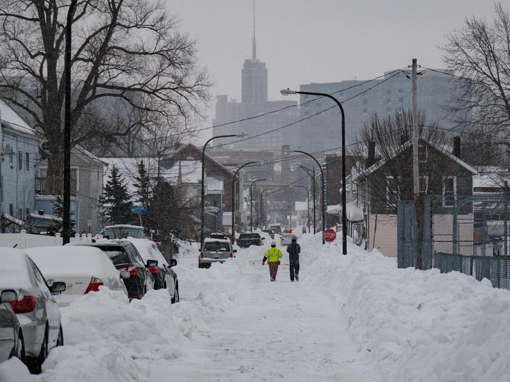 National Grid workers respond to a downed utility pole in Buffalo, N.Y., on Tuesday. The monster storm that killed dozens in the United States over the Christmas weekend continued to inflict misery on New York state and air travelers nationwide.
