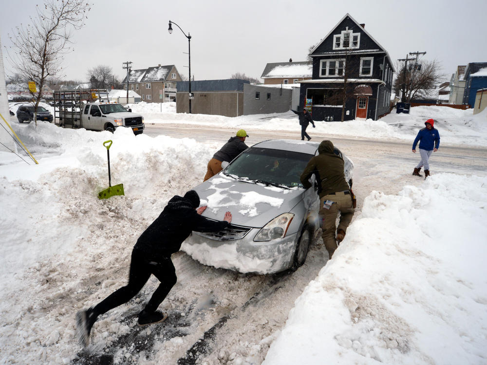 Good Samaritans help push out a car in Buffalo, N.Y., on Tuesday.