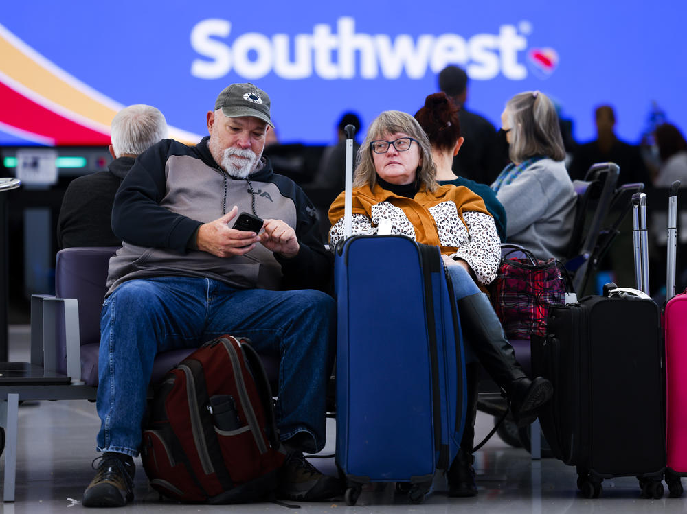 John and Lori Ingoldsby, who drove to Denver after the first leg of their flight on Southwest Airlines was canceled, wait for a flight to finish their trip at Denver International Airport on December 28, 2022 in Denver, Colorado.