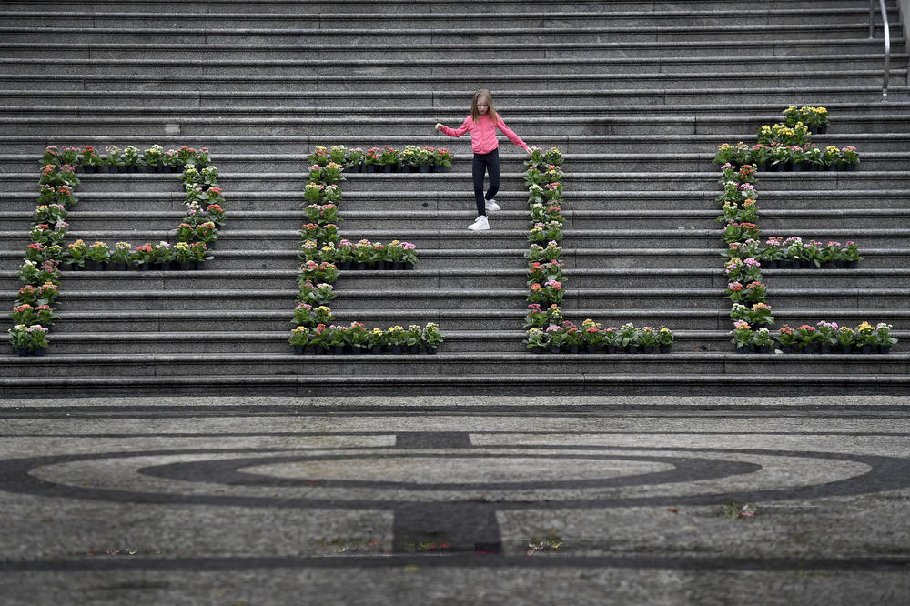 A girl walks among a floral arrangement for the late Brazilian soccer star Pelé at the City Hall in Santos, Brazil, on Friday.