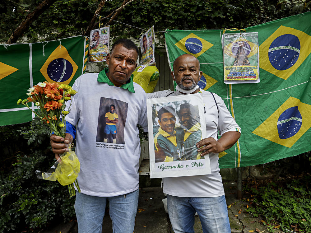Antonio da Paz (left) and Renato Souza stand in front of the Albert Einstein Hospital holding memorabilia honoring Brazilian soccer star Pelé, in Sao Paulo on Friday.
